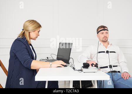 Imprenditore si siede per un lie detector l'esame. Foto Stock
