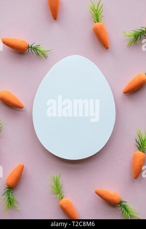 Composizione di pasqua con vuoto bianco Uova di Pasqua e il coniglietto di pasqua le carote Foto Stock