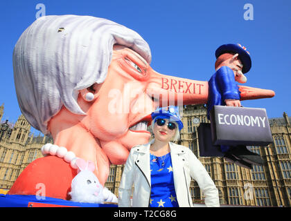 Westminster, Londra, Regno Unito. 1 aprile 2019. Madeleina Kay, attivista e "EU Supergirl”. Un gigantesco fluttuante della Brexit, che mostra ed effigie del primo ministro Theresa May, con l'economia britannica attaccata al naso lungo, è visto fuori dalle camere del Parlamento, mentre i manifestanti anti anti-Brexit si radunano ancora una volta a Westminster in un altro giorno di votazione sugli emendamenti in Parlamento. L'effigie è opera del noto designer di galleggianti e scultura Jacques Tilly ed è stata originariamente creata per il carnevale di Duesseldorf in Germania. Foto Stock