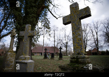 19 marzo 2019, Meclemburgo-Pomerania, Conow: Weathered lapidi e croci in pietra davanti alla chiesa del paese di Conow in Luterano ed Evangelico parrocchia. Foto: Christian Charisius/dpa Foto Stock