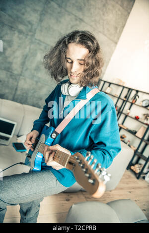 Incurante con i capelli lunghi uomo ispirato durante la riproduzione di musica Foto Stock