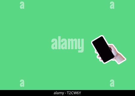 Collage in stile rivista e pop art style. Mano azienda smartphone su sfondo verde Foto Stock