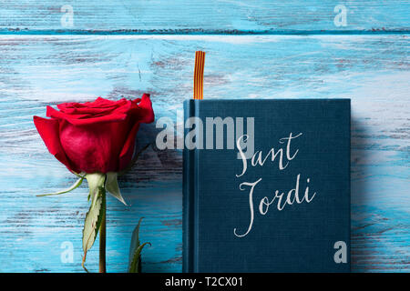 Angolo di alta vista di una rosa rossa e un libro con il testo Sant Jordi, il nome catalano per Saint George giorno, quando è tradizione per dare rose rosse e b Foto Stock