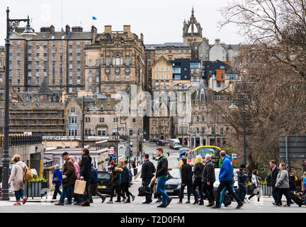 Pedoni che attraversano street con la Città Vecchia alla parte posteriore nel centro di Edimburgo, Scozia, Regno Unito Foto Stock