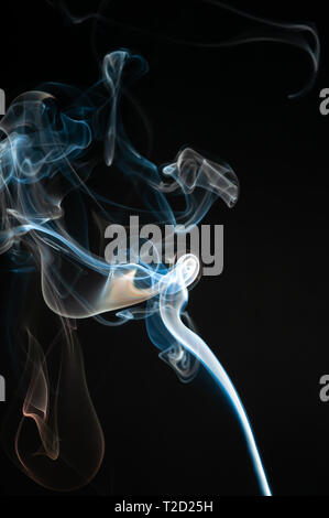 Bianco isolato e fumo blu su sfondo nero. Elemento di design. Fumo naturale. Foto Stock