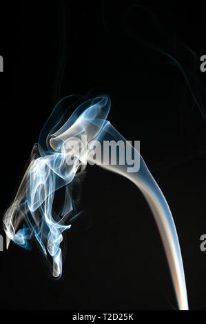 Bianco isolato e fumo blu su sfondo nero. Elemento di design. Fumo naturale. Foto Stock