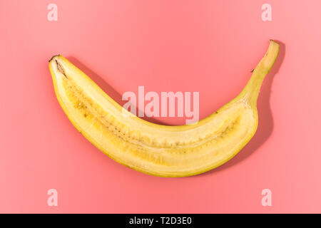 Fette di banana sul rosa pastello sfondo. La minima nozione di frutta. Caontrast ombre Foto Stock