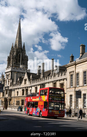 Un hop on-hop off-autobus turistico passando l'università chiesa di Santa Maria Vergine, nella High Street a Oxford, Gran Bretagna Foto Stock