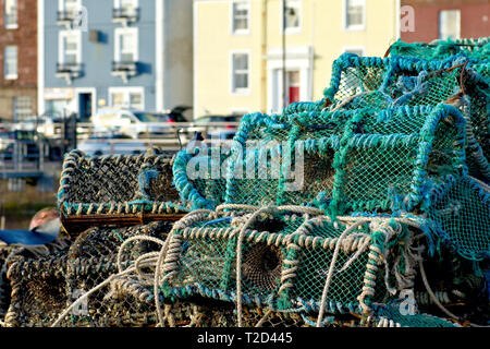 Il granchio pentole o cantre impilati sulla banchina del porto di Arbroath con la Riva in background, Angus, Scozia. Foto Stock