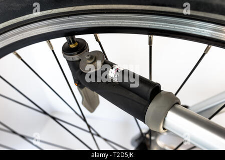 Il pompaggio della ruota di bicicletta utilizzando una pompa a mano con aria indicatore di pressione in unità di bar / psi. Foto Stock