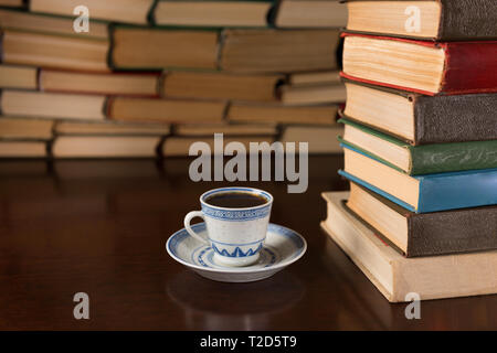Libri e una tazza di caffè su di un tavolo di legno Foto Stock