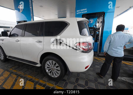 L'uomo riempiendo il suo SUV serbatoio del carburante in corrispondenza di una stazione di benzina in Dubai Emirati Arabi Uniti Foto Stock