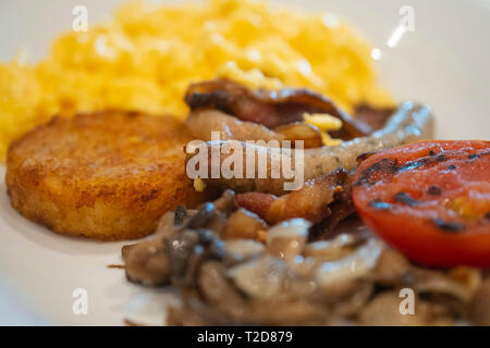 Piastra di colazione con uova strapazzate, salsicce, pomodori e un hash browns Foto Stock