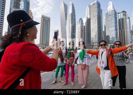 Turisti asiatici in posa per fotografie a Dubai Marina, Dubai, Emirati Arabi Uniti Foto Stock