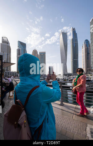 Turisti asiatici in posa per fotografie a Dubai Marina, Dubai, Emirati Arabi Uniti Foto Stock