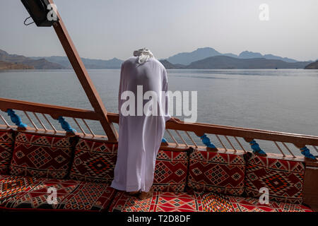 Cruise tour a bordo di un decorata tradizionalmente con Sambuco Arabo barca di legno lungo le montagne rocciose della penisola di Musandam in Oman Fiordi Foto Stock