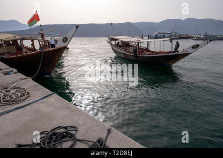 Cruise tour a bordo di un decorata tradizionalmente con Sambuco Arabo barca di legno lungo le montagne rocciose della penisola di Musandam in Oman Fiordi Foto Stock