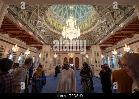 I turisti all'interno della sala di preghiera Al Sultan Qaboos grande moschea in Muscat Oman Foto Stock