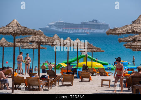 Le persone che si godono la spiaggia di Sir Bani Yas Island con la nave da crociera MSC Splendida in mare in background Foto Stock