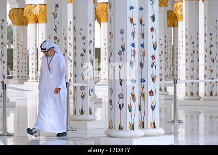 L'uomo indossando il tradizionale kandura bianco vestiti emirati Sheikh Zayed Grande Moschea di Abu Dhabi, Emirati Arabi Uniti Foto Stock