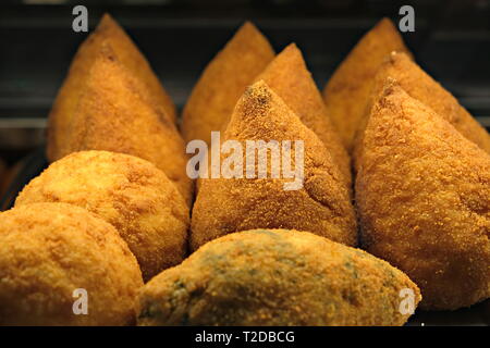 Chiudere la vista su un tipico siciliano di snack: una sfera di riso fritto denominato 'arancino' Foto Stock