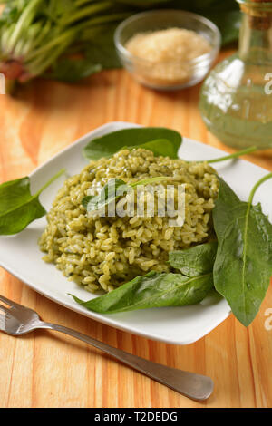 Italian risotto con gli spinaci nel piatto bianco - ricetta vegetariana - primo piano Foto Stock