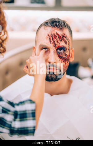 L'uomo con il trucco sulla sua faccia con ferite e sangue. Foto Stock