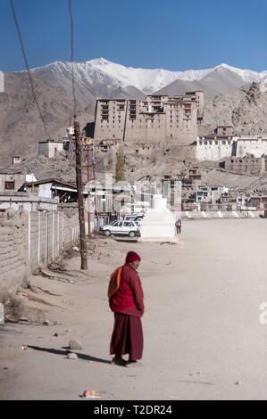 Un monaco si avvicina verso il vecchio palazzo in montagna himalayana città di Leh, Ladakh, Jammu e Kashmir. India. Foto Stock