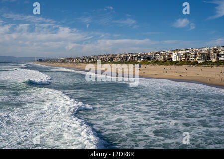 Nel tardo pomeriggio cityscape vista di Manhattan Beach California, come si vede dal molo, come le onde dell'Oceano Pacifico in rotolo Foto Stock
