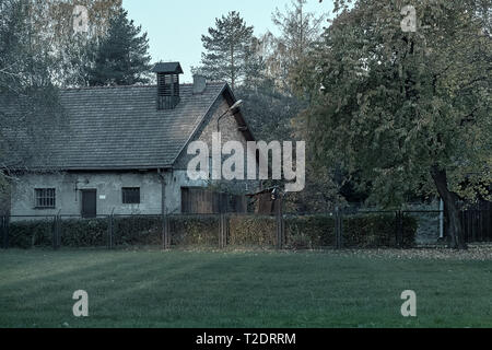 Vecchia casa e una recinzione con fili elettrici in Auschwitz Osventsim campo di concentramento - una rete di nazista tedesco nei campi di concentramento e di sterminio cam Foto Stock