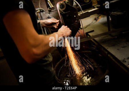 Coltello per affilatura maschio sulla macchina per affilatura in officina Foto Stock