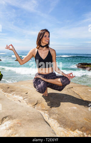 Bella donna fare yoga dall'oceano a la Jolla, California Foto Stock