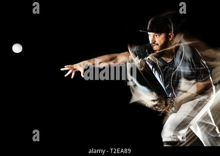 Un caucasian giocatore di baseball uomo studio shot isolato su sfondo nero con luce di verniciatura effetto di velocità Foto Stock