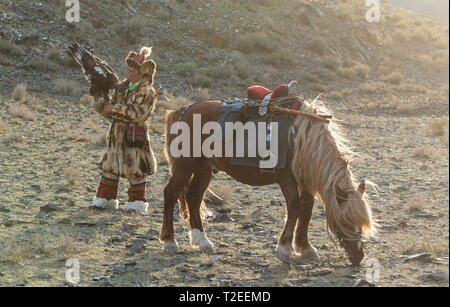 Il bayan Ulgii, Mongolia, 3 ottobre 2015: il kazako eagle cacciatore con la sua aquila e da un cavallo Foto Stock