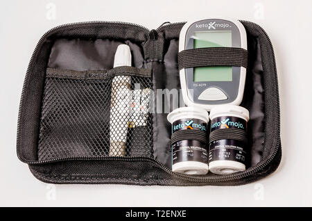 Un Keto-Mojo chetone e di monitoraggio del glucosio nel sangue è il kit raffigurata sul bianco, con la metro, chetone e strisce di prova di glucosio, e dispositivo di lancet. Foto Stock