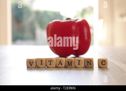 Le parole di vitamina C con un organico fresco il peperone su un tavolo da cucina, il fuoco selettivo in primo piano, cibo sano concetto Foto Stock