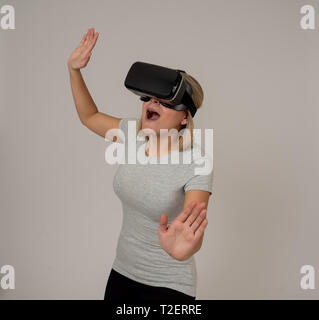 Curioso stupiti teen donna utilizzando aumentate o occhiali VR, sensazione di entusiasti di simulazione, esplorare e interagire con la realtà virtuale rendendo gestu Foto Stock