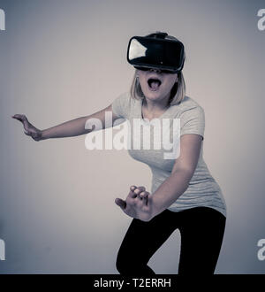 Curioso stupiti teen donna utilizzando aumentate o occhiali VR, sensazione di entusiasti di simulazione, esplorare e interagire con la realtà virtuale rendendo gestu Foto Stock