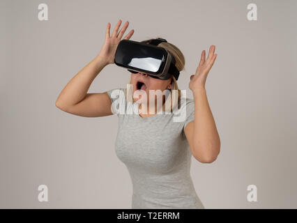 Stupiti donna prendere l'esperienza utilizzando cuffie VR occhiali, sensazione entusiasti di simulazione, esplorare la realtà virtuale compiendo gesti interagenti con Foto Stock