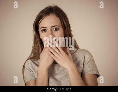 Close up ritratto di Giovane ragazza adolescente in stato di shock con faccia spaventata compiendo gesti spaventati e guardando qualcosa di spaventare. Le emozioni umane sensazione Foto Stock