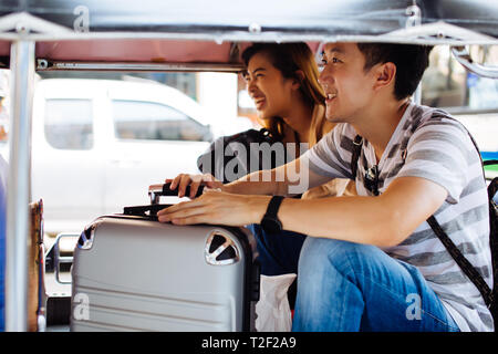 Coppia giovane turista esplorare Bangkok con locale tuk tuk taxi mentre si è in viaggio in Tailandia Foto Stock
