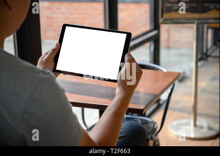 Imprenditore lavora a mano su tablet sulla scrivania in legno tablet con schermo vuoto mockup digitali computer tablet Foto Stock