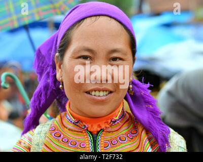 Matura fiore vietnamita H'mongs donna indossa il colorato costume tradizionale del fiore H'mongs persone, un velo di colore blu e piccoli orecchini. Foto Stock