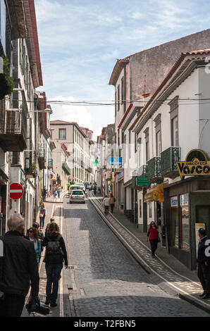 PONTA Delgada, Portogallo - 10 Maggio 2012: una delle tipiche stradine strette nel centro della citta'. La gente a piedi sui marciapiedi foderato con schemi di posa Foto Stock