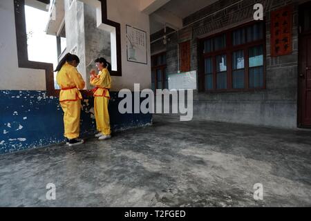 (190402) -- JINPING, 2 aprile 2019 (Xinhua) -- Due faccia dipinta gli studenti a parlare tra di loro a Longli medio e la scuola primaria in Jinping County, a sud-ovest della Cina di Guizhou, il 20 marzo 2019. Classificato come Patrimonio culturale immateriale di Guizhou in 2005, Longli il drago danza ha una storia di più di 600 anni. Esso è caratterizzato dai ballerini' bella faccia dipinta. Dal 2008, Longli's dragon dance è stato introdotto in Longli medio e la scuola primaria di cui gli studenti godono di due ore alla settimana con dragon dance masters per saperne di costume rendendo, danza competenze e f Foto Stock