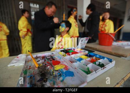 (190402) -- JINPING, 2 aprile 2019 (Xinhua) -- insegnanti dipingere le facce degli studenti in preparazione per il Drago ballo a Longli medio e la scuola primaria in Jinping County, a sud-ovest della Cina di Guizhou, il 20 marzo 2019. Classificato come Patrimonio culturale immateriale di Guizhou in 2005, Longli il drago danza ha una storia di più di 600 anni. Esso è caratterizzato dai ballerini' bella faccia dipinta. Dal 2008, Longli's dragon dance è stato introdotto in Longli medio e la scuola primaria di cui gli studenti godono di due ore alla settimana con dragon dance masters per saperne di costume Foto Stock