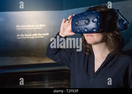 Berlino, Germania. 02Apr, 2019. Un museo dipendente indossa occhiali 3D nella Alte Nationalgalerie con cui l'opera d'arte 'Mönch am Meer' dal pittore Caspar David Friedrich può essere sperimentato praticamente. Dal 5 Aprile al 30 giugno 2019, i visitatori possono prendere il viaggio virtuale. (Per dpa: 'Visitare il 'monk dal mare" - Vista virtuale della icona romantica' dal 03.04.2019). Credito: Jörg Carstensen/dpa/Alamy Live News Foto Stock