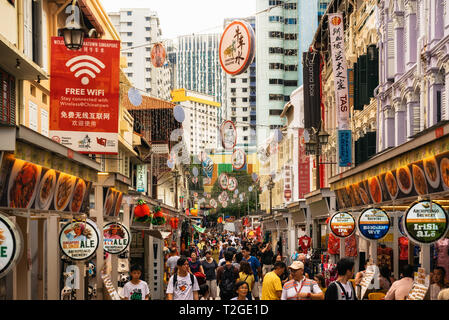 Chinatown, Singapore - 8 Febbraio 2019: la strada affollata con cibo di strada in Chinatown contro il quartiere centrale degli affari di Singapore Foto Stock