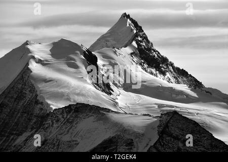 Monocromatico del Bishorn (sinistra) e il Weisshorn nel sud delle Alpi Svizzere tra Zinal e Zermatt. Catturate la sera sun Foto Stock