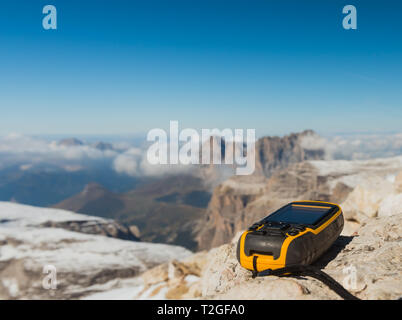 Il navigatore GPS in mano contro Dolomiti Alpi Foto Stock